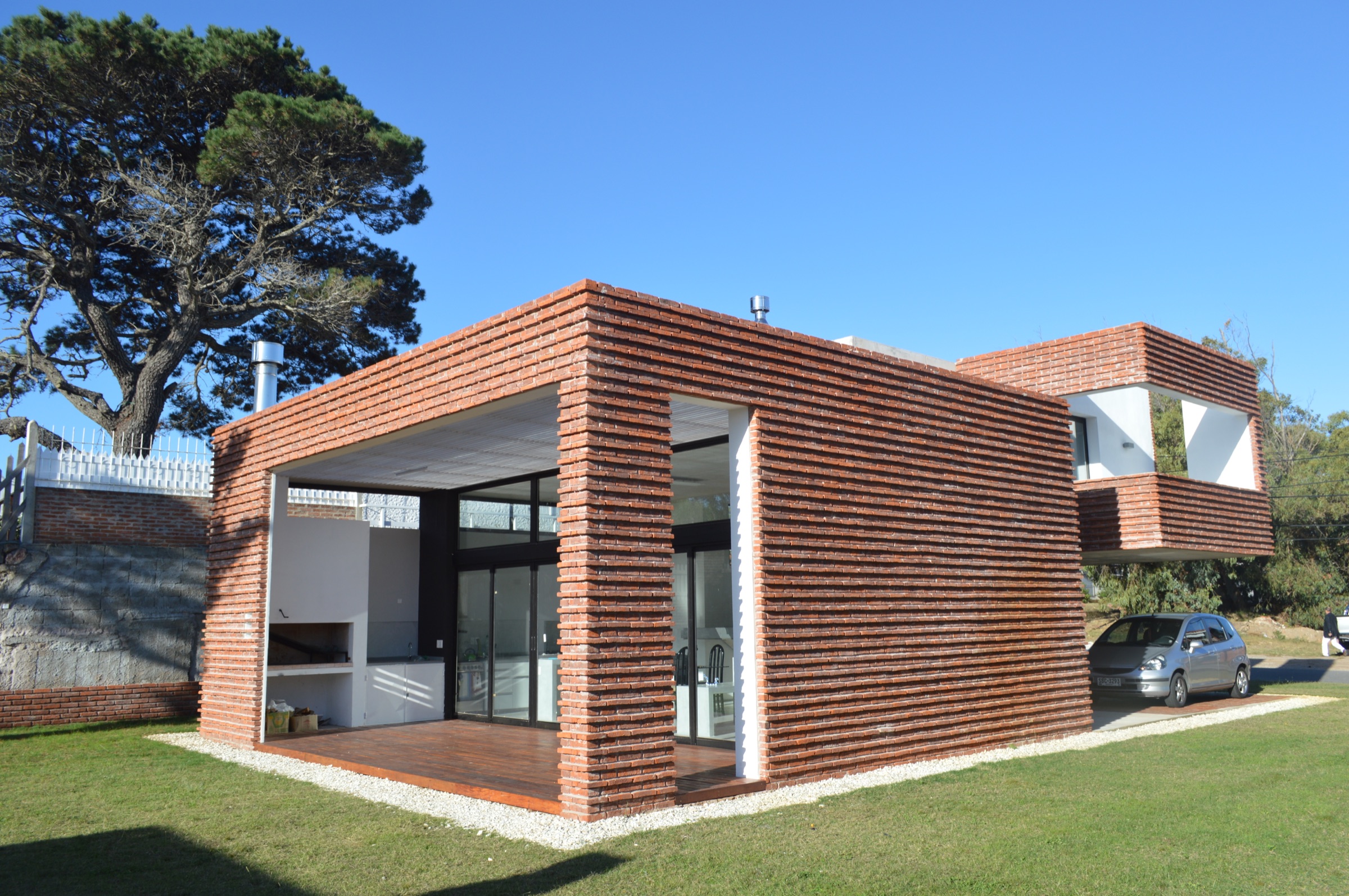 Volumen social de Casa A abierto hacia el jardín