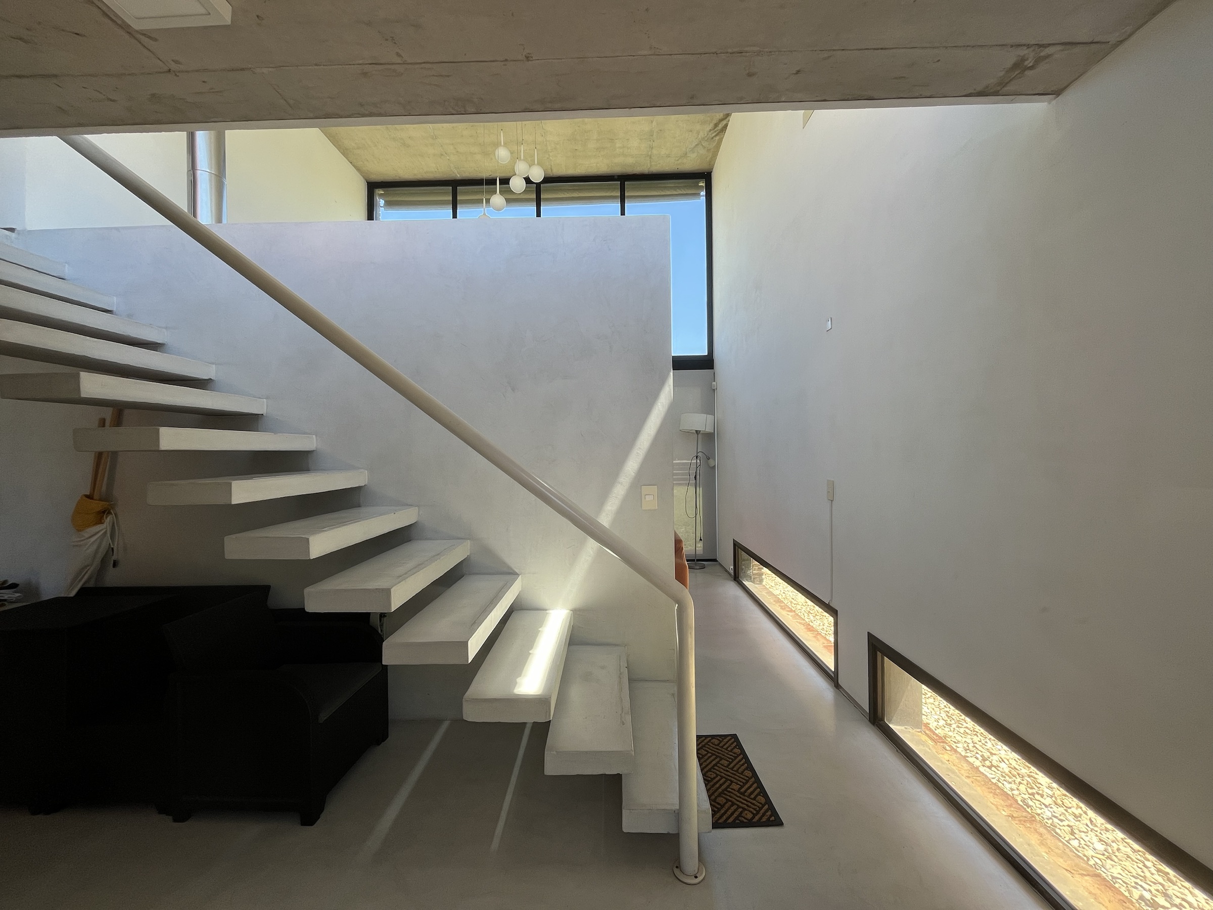 Sombras lineales proyectadas por una pérgola blanca