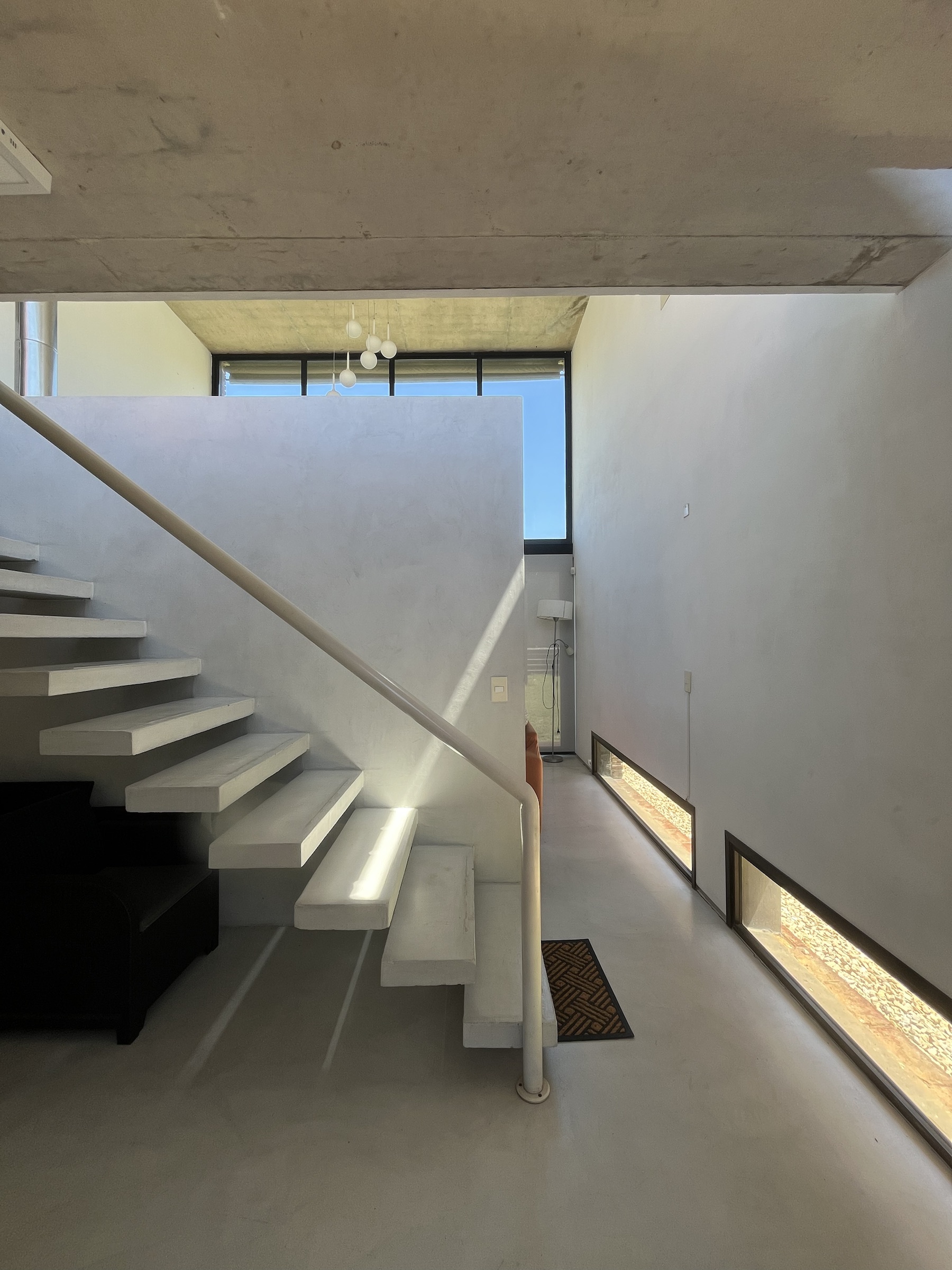 Escalera de Casa I bajo la luz natural del volumen principal